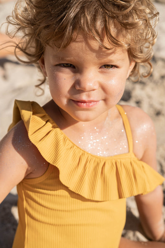 Toddler wearing Bio-glitter and SunDust Bio-glitter sunscreen
